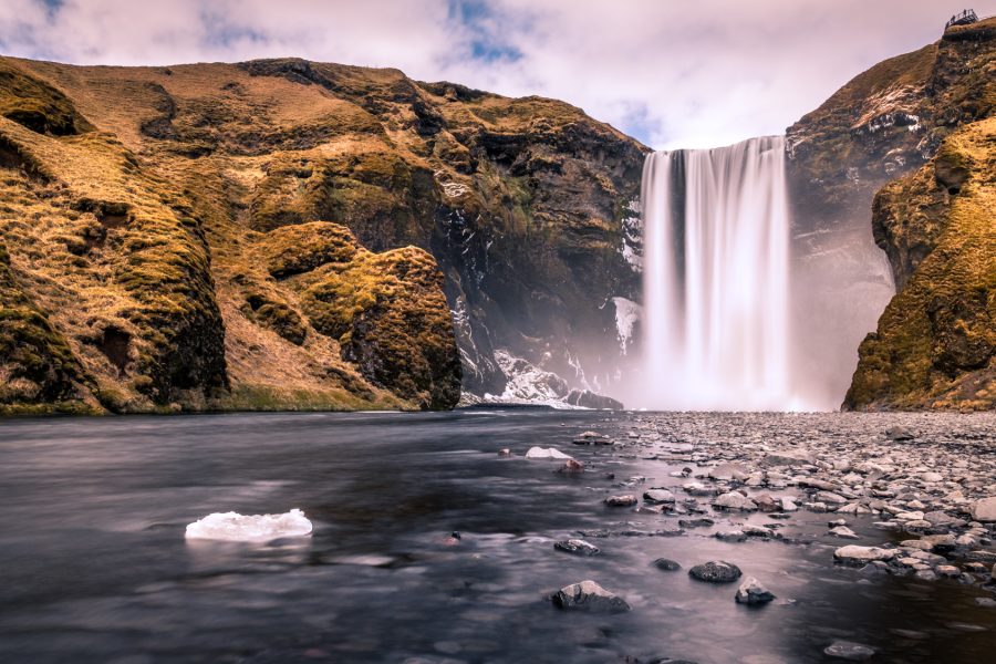 Skogafoss waterfall in Iceland plunging from a steep cliff into a green landscape