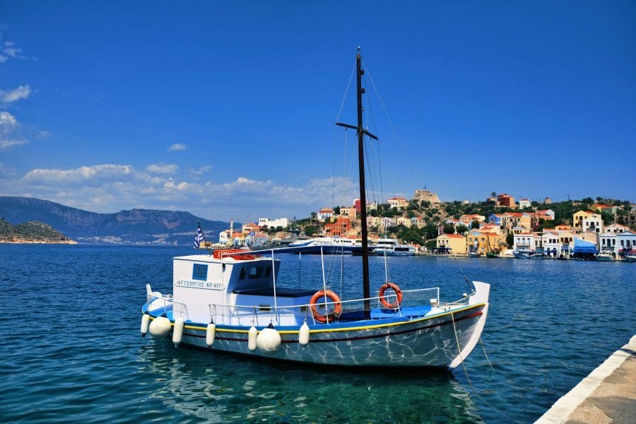 Καΐκι στο λιμάνι του Καστελόριζου με τα χρωματιστά αρχοντικά